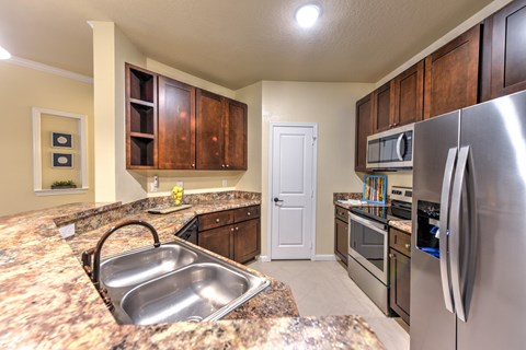 A kitchen with a granite counter top and stainless steel appliances at Cabana Club - Galleria Club Apartments, Jacksonville, FL, 32256